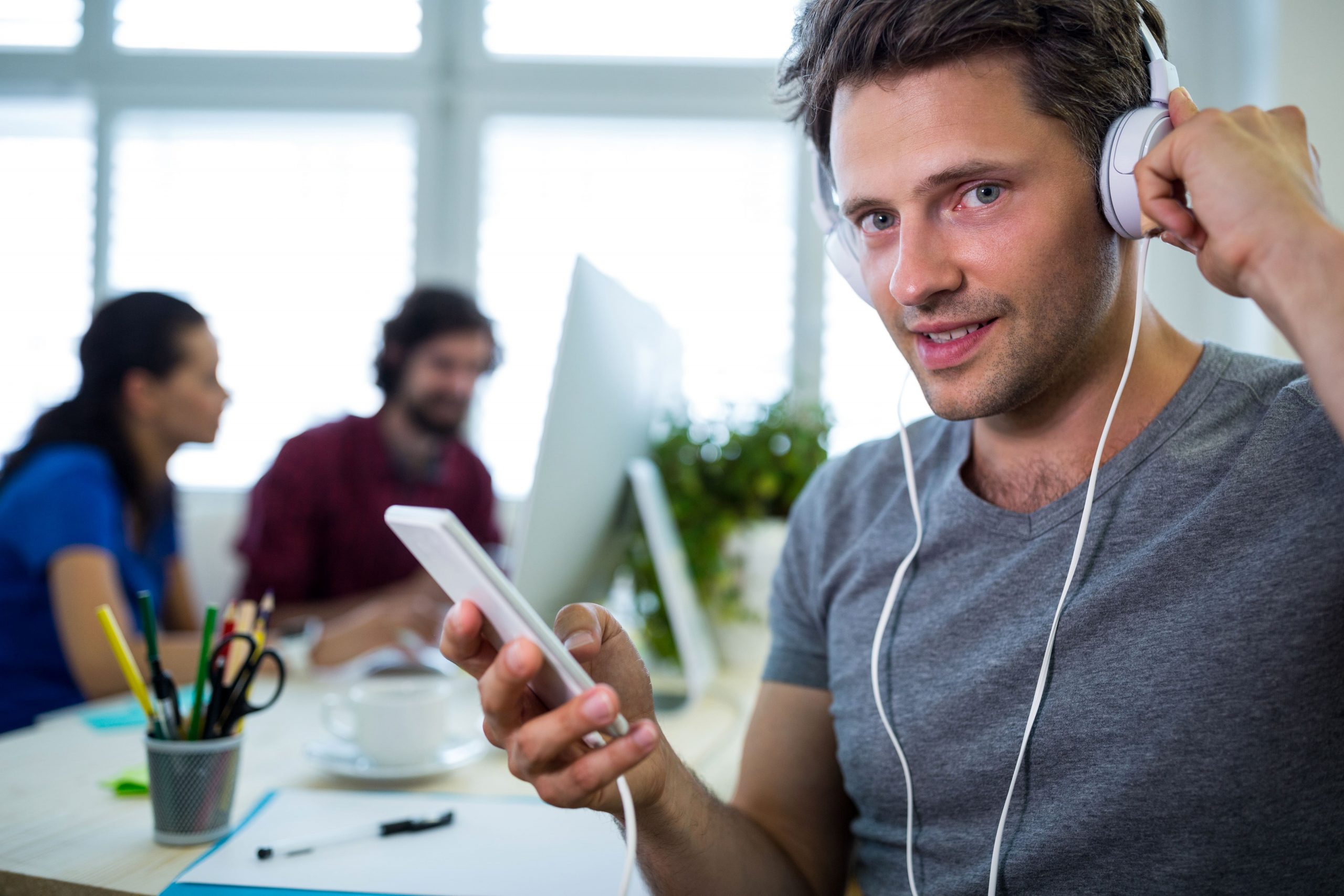 Personne avec casque audio et téléphone en main, concentrée closing